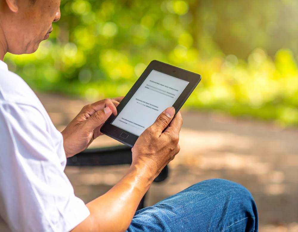 man reading an e-book outside
